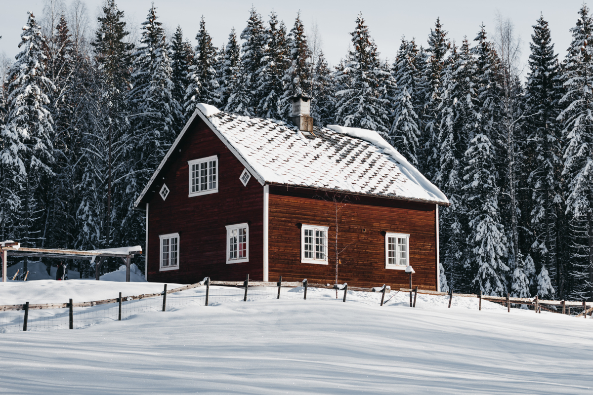 Red farm house in winter landscape.