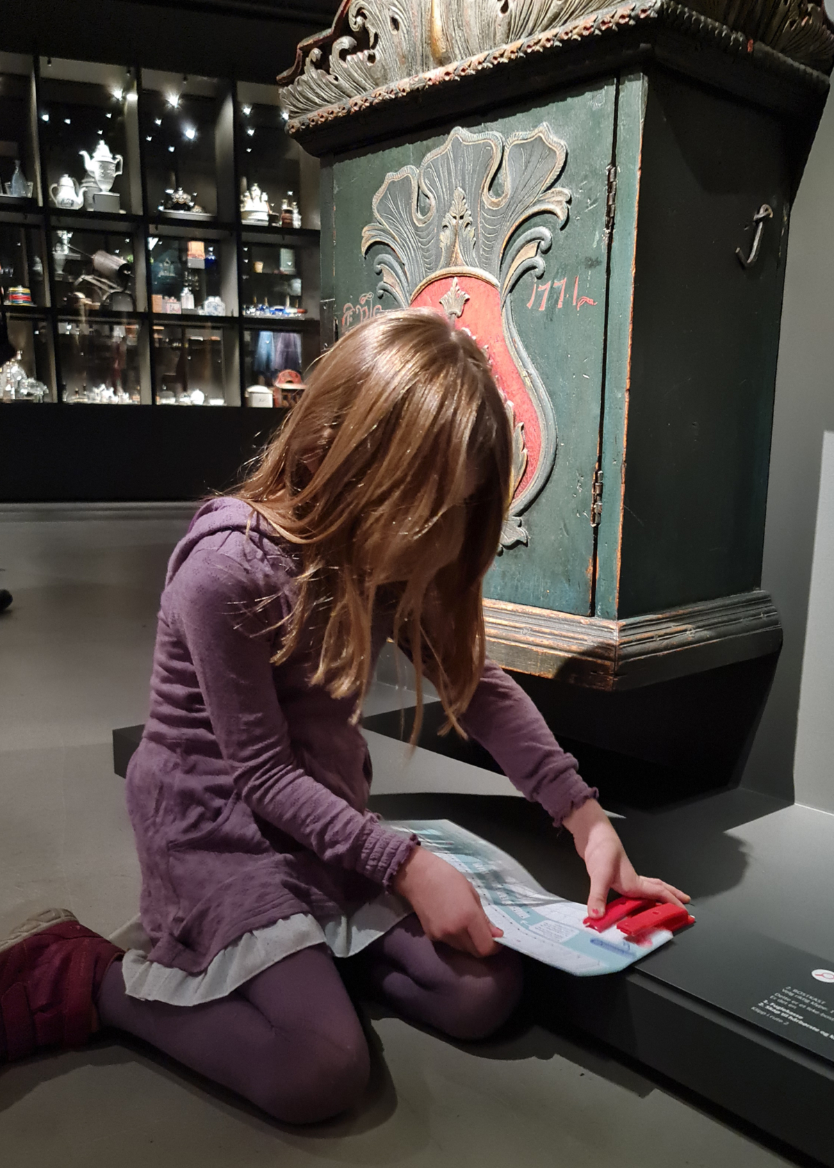 Girl punching a mark in a folder in the exhibition Impulses.