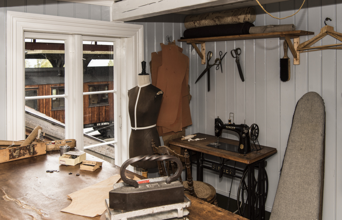 The tailor's workshop with historical equipment like sewing machine, iron, scissors and more.